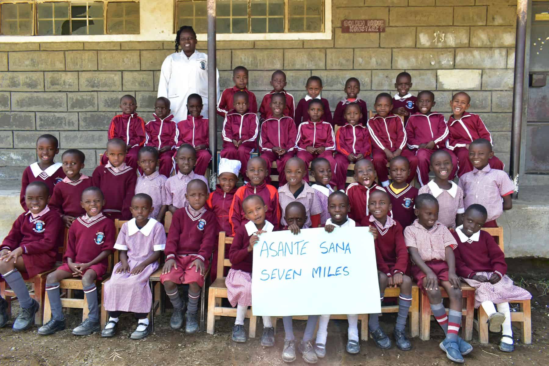 school children holding seven miles sign